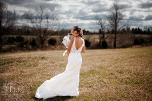 cincinnati wedding photographer captures a bride in a sleek gown standing and smiling while the wind blows