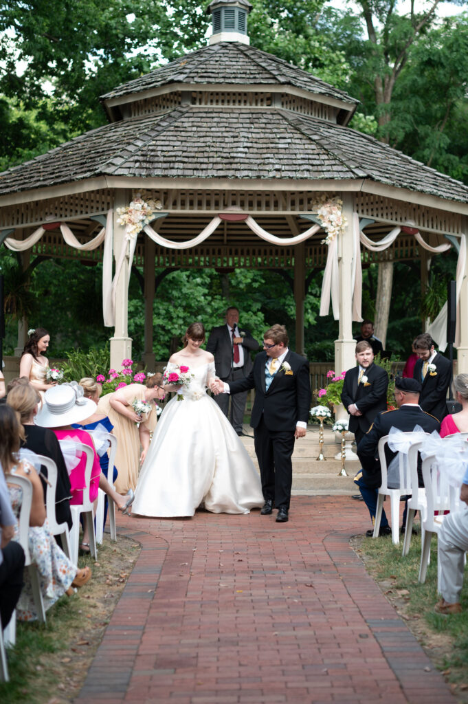 The bride and groom begin their walk back down the aisle together, now as husband and wife. 